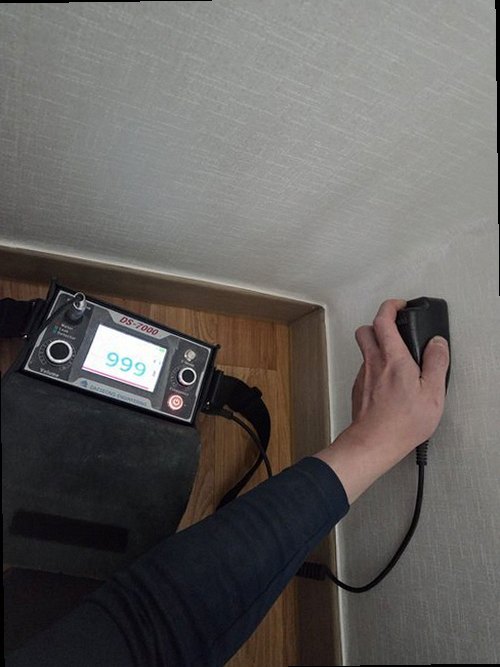 부평구 누수탐지 안방 벽면의 물자국과 수분 측정기를 확인하는 모습